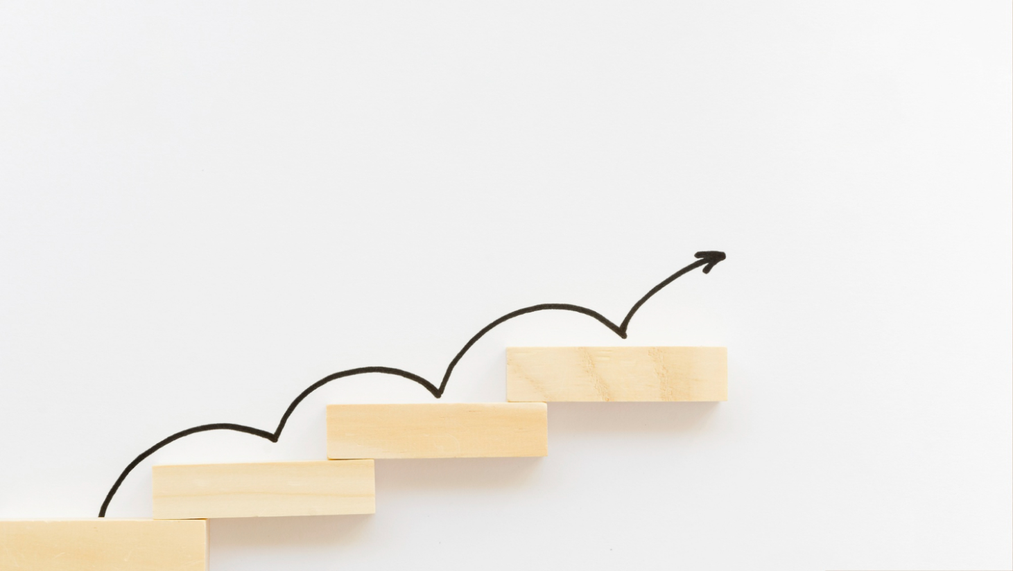 Drewniane schodki po których wspina się strzałka czarna