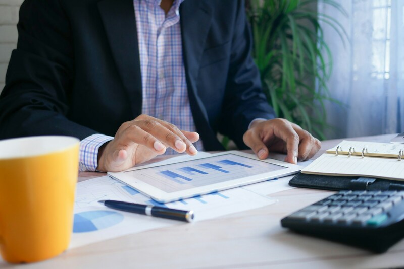 Un entrepreneur gère ses finances devant son ordianteur, et calcule la taxe