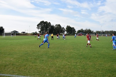 Zdjęcie boiska i grających na nim piłkarzy.